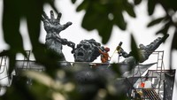 Pekerja membersihkan monumen Pembebasan Irian Barat di Lapangan Banteng, Jakarta, Kamis (19/9/2024).   