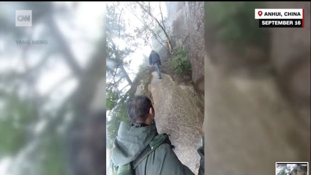 Escena de un escalador deslizándose por un valle de montaña.