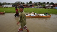 Salah satu nelayan berjalan di sebelah perahunya yang penuh dengan makanan di Danau Aleixo selama musim kemarau di Manaus.