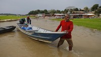 Nelayan mendorong perahu di Danau Aleixo selama musim kemarau di Manaus, negara bagian Amazonas, Brasil, Selasa (24/9/2024).
