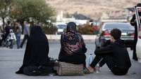 Warga Lebanon yang melarikan diri dari pemboman Israel, duduk di tanah saat tiba di perbatasan Suriah-Lebanon di Jdeidet Yabous, Suriah, Selasa (24/9/2024).  