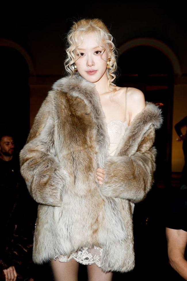 Rose BLACKPINK tampil memakai silk dress dengan detail enda berwarna gold di balik mantel bulu serasi dari Saint Laurent. Foto: Aitor Rosas Sune/WWD via Getty Images
