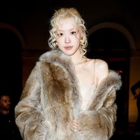 Rose BLACKPINK tampil memakai silk dress dengan detail enda berwarna gold di balik mantel bulu serasi dari Saint Laurent. Foto: Aitor Rosas Sune/WWD via Getty Images