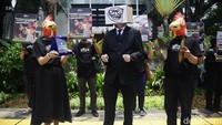 Aksi berupa pertunjukan yang menampilkan seorang figur bertopeng diiringi suara simbal, serta membawa banner dan poster.