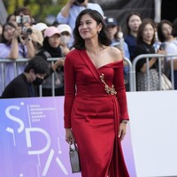 Dian melengkapi gayanya dengan clutch bag warna silver metalik strappy heels bernuansa senada. Foto: AP/Lee Jin-man