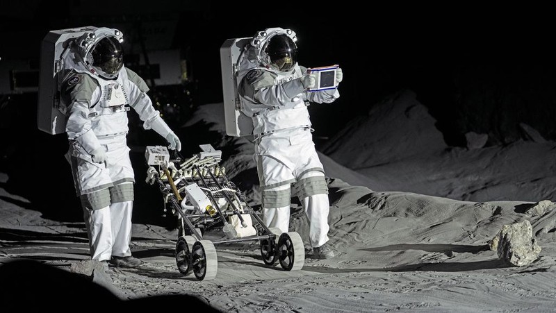 An astronaut cheers with ESA director Josef Aschbacher after a training in lunar surface simulating conditions for future moon missions, like the Artemis lunar exploration program led by NASA, at the opening of the new LUNA facility at the European Astronaut Center, near Cologne, Germany, Wednesday, Sept. 25, 2024. (AP Photo/Martin Meissner)