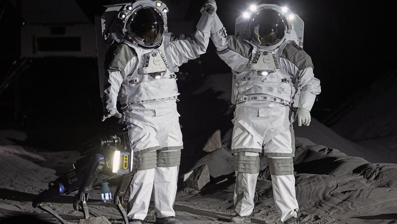 An astronaut cheers with ESA director Josef Aschbacher after a training in lunar surface simulating conditions for future moon missions, like the Artemis lunar exploration program led by NASA, at the opening of the new LUNA facility at the European Astronaut Center, near Cologne, Germany, Wednesday, Sept. 25, 2024. (AP Photo/Martin Meissner)