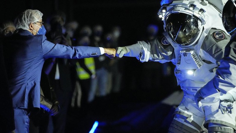 An astronaut cheers with ESA director Josef Aschbacher after a training in lunar surface simulating conditions for future moon missions, like the Artemis lunar exploration program led by NASA, at the opening of the new LUNA facility at the European Astronaut Center, near Cologne, Germany, Wednesday, Sept. 25, 2024. (AP Photo/Martin Meissner)