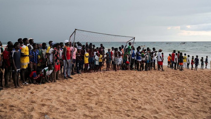 Keseruan Warga Senegal Nonton Pertandingan Sepakbola Girls watch from afar a soccer game between two teams from the neighborhood in Toubab Dialaw on the outskirts of Dakar, Senegal, September 25, 2024.REUTERS/Zohra Bensemra TPX IMAGES OF THE DAY
