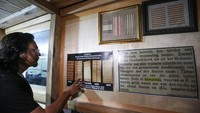 Seorang wisatawan melihat mata uang kampua pada kesultanan Buton di kawasan Benteng Keraton Kesultanan Buton.