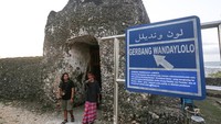 Wsatawan berjalan keluar dari salah satu gerbang di kawasan Benteng Keraton Kesultanan Buton, Kota Baubau, Sulawesi Tenggara.