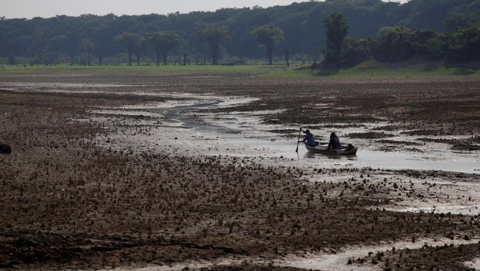 Fishermen navigate in the middle of the dry bed of the Puraquequara lake caused by severe drought in the Amazon, in Manaus, Brazil September 25, 2024. REUTERS/Bruno Kelly