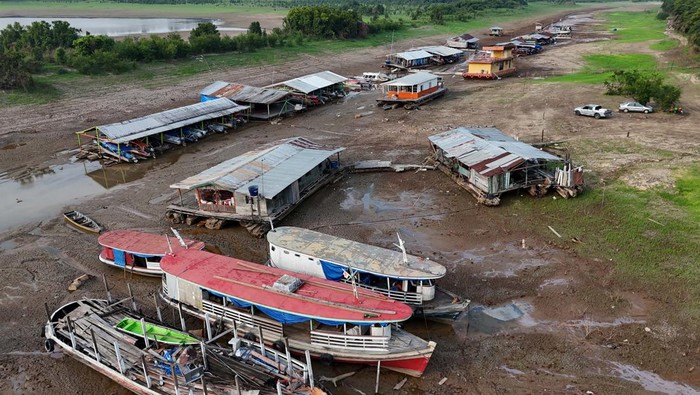 Fishermen navigate in the middle of the dry bed of the Puraquequara lake caused by severe drought in the Amazon, in Manaus, Brazil September 25, 2024. REUTERS/Bruno Kelly