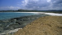 Tanjung Aan adalah tempat yang sempurna untuk berjemur dan bersantai dengan pasir yang lembut dan pemandangan laut yang biru. Pantai ini juga dikenal dengan keunikan hamparan pasirnya yang berwarna putih dan cokelat. (Veronique DURRUTY/Gamma-Rapho via Getty Images) 