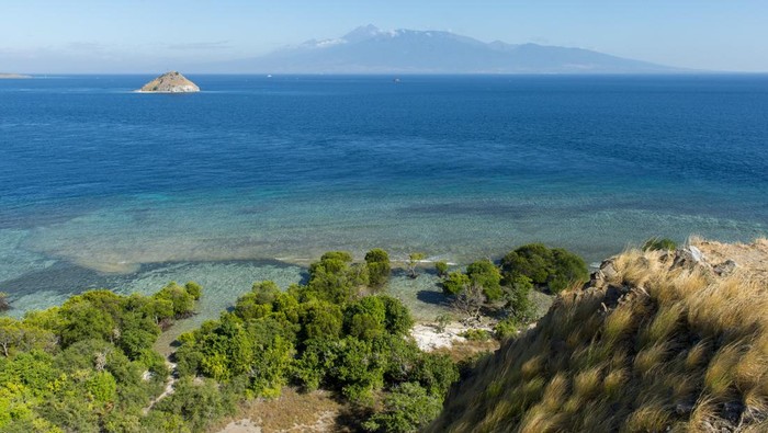 6 Wisata Menakjubkan yang Harus Kamu Kunjungi Saat Menyaksikan MotoGP INDONESIA - 2019/05/26: View from the hill on Gili Kenawa, a small island of the coast of Sumbawa, Indonesia, Lombok Island with the active volcano Mount Rinjani or Gunung Rinjani in the background. (Photo by Wolfgang Kaehler/LightRocket via Getty Images)