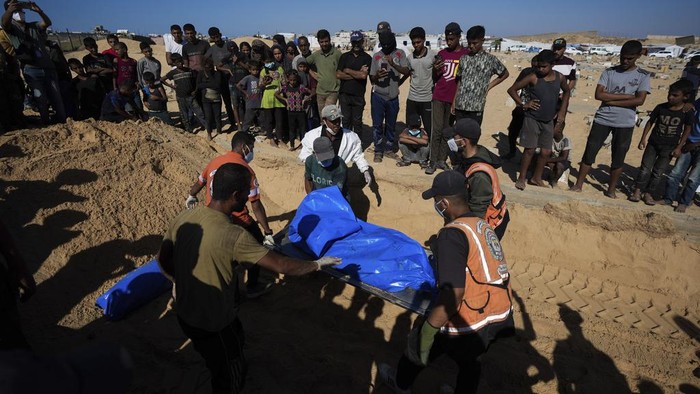 Israel Kirim 88 Jenazah Warga Palestina Tanpa Identitas, Ditumpuk dalam Truk People bury the bodies of Palestinians taken by the Israeli military during operations in Gaza and returned this week, in Khan Younis, Gaza Strip, Thursday, Sept. 26, 2024. (AP Photo/Abdel Kareem Hana)