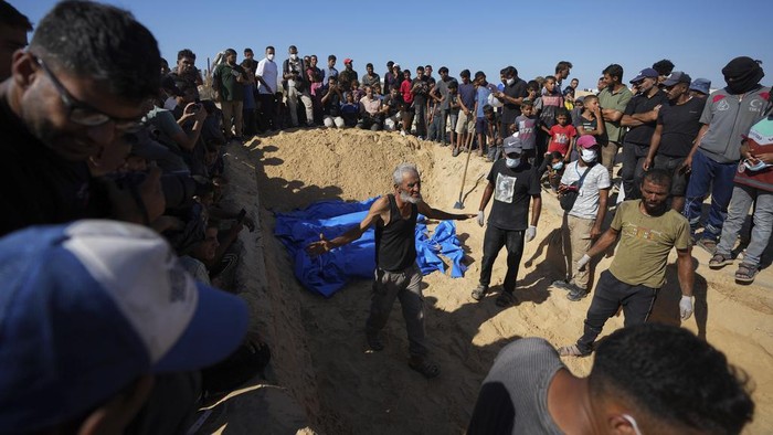 Israel Kirim 88 Jenazah Warga Palestina Tanpa Identitas, Ditumpuk dalam Truk People bury the bodies of Palestinians taken by the Israeli military during operations in Gaza and returned this week, in Khan Younis, Gaza Strip, Thursday, Sept. 26, 2024. (AP Photo/Abdel Kareem Hana)