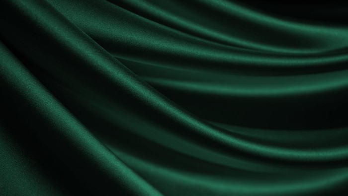 Dark green silk satin velvet. Nice soft folds. Shiny fabric. Wavy lines. Elegant background for design.