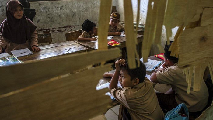 Sejumlah siswa mengikuti kegiatan belajar mengajar di ruang kelas SD Negeri Cijakan 3, Kabupaten Pandeglang, Banten, Jumat (27/9/2024). Sekolah tersebut mengalami kerusakan karena terdampak proyek pembangunan Tol Serang-Panimbang seksi III Cileles-Panimbang, dan hingga kini belum ada upaya perbaikan yang berarti dari pihak terkait ataupun relokasi untuk kegiatan belajar mengajar. ANTARA FOTO/Angga Budhiyanto/gp/Spt.