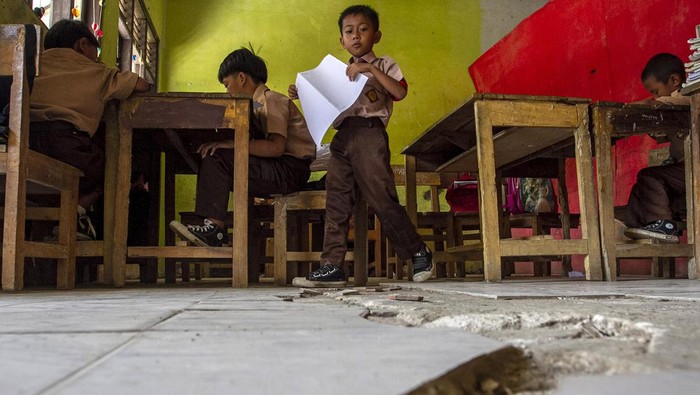 Sejumlah siswa mengikuti kegiatan belajar mengajar di ruang kelas SD Negeri Cijakan 3, Kabupaten Pandeglang, Banten, Jumat (27/9/2024). Sekolah tersebut mengalami kerusakan karena terdampak proyek pembangunan Tol Serang-Panimbang seksi III Cileles-Panimbang, dan hingga kini belum ada upaya perbaikan yang berarti dari pihak terkait ataupun relokasi untuk kegiatan belajar mengajar. ANTARA FOTO/Angga Budhiyanto/gp/Spt.