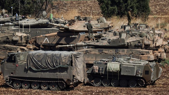 People work on Israeli Army tanks, amid cross-border hostilities between Hezbollah and Israel, in northern Israel, September 27, 2024. REUTERS/Jim Urquhart