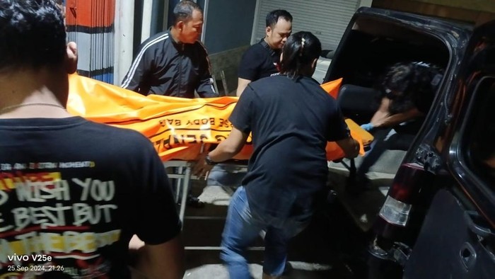 Polisi saat mengevakuasi jasad wanita yang ditemukan dalam lemari