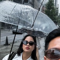 Meski Jepang tengah diguyur hujan namun Nino dan istrinya tetap terlihat ceria dan bersemangat menghabiskan bulan madu mereka. Sambil sama-sama memegang payung, keduanya pun wefie di jalanan Jepang. Foto: Instagram/@ninokayam