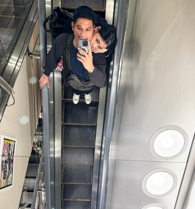 Berpose di eskalator, Dhabitannisa tampak berdiri di belakang Nino sambil menyenderkan kepalanya di pundak suaminya itu. Foto: Instagram/@ninokayam