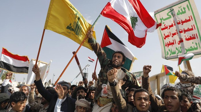 Houthi supporters raise a Lebanese flag during an anti-Israel and anti-U.S. rally in Sanaa, Yemen, Friday, Sept. 27, 2024. Arabic reads, 