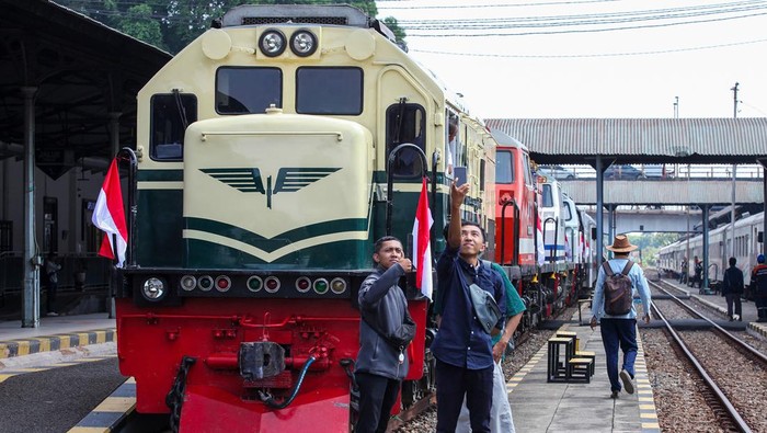Warga melakukan swa foto dengan latar belakang rangkaian lokomotif kekhasan (livery) saat Parade Lokomotif di Stasiun Surabaya Gubeng, Surabaya, Jawa Timur, Sabtu (28/9/2024). PT Kereta Api Indonesia Daop 8 Surabaya menggelar parade empat lokomotif kekhasan (livery) dengan menempuh rute jalur kereta api Surabaya Gubeng - Wonokromo - Sidoarjo - Tulangan - Tarik dan kembali ke Surabaya Gubeng untuk memperingati Hari Ulang Tahun ke-79 Kereta Api Indonesia. ANTARA FOTO/Didik Suhartono/agr