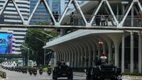 Sebagian warga melihat iring-iringan alutsista dari jembatan penyeberangan orang. 