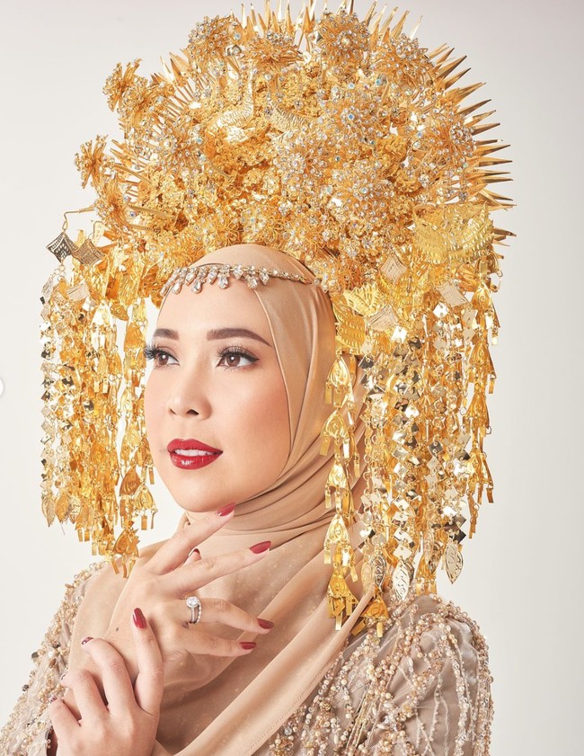 Melengkapi penampilannya dengan suntiang Minang, Fitrop tampil menawan. Penampilannya itu juga semakin dipercantik dengan riasan natural glam dan lipstik merah yang senada dengan cat kuku yang dikenakannya. Foto: Instagram/@fitrop