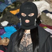 Hanya mata dan mulut yang terlihat di balik masker berwarna hitam tersebut. Namun dia tetap menunjukkan sisi glamor dengan sepasang anting berlian panjang. Foto: Dominique Charriau/WireImage