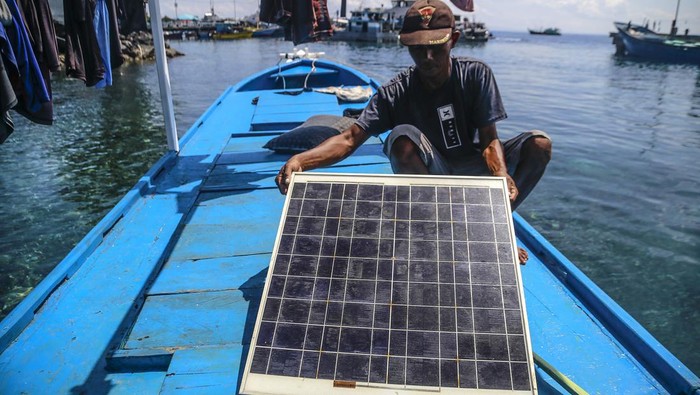 Nelayan memasang panel surya di atas kapalnya sebelum melaut di Pelabuhan Perikanan Ternate, Maluku Utara, Senin (30/9/2024). Nelayan yang menggunakan kapal berukuran 6-10 gross ton (GT) tersebut memanfaatkan pembangkit listrik tenaga surya (PLTS) sebagai sumber energi listrik saat melaut  agar lebih hemat bahan bakar minyak. ANTARA FOTO/Andri Saputra/YU