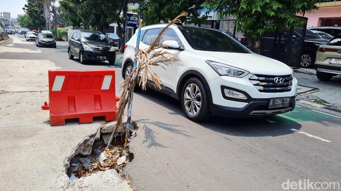 Kendaraan melintasi jalan rusak yang berlubang di Jalan Kampung Melayu Besar, Tebet, Jakarta Selatan, Senin (30/9/2024).