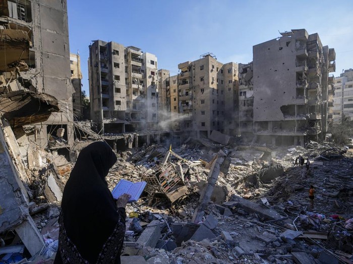 A woman reads the Quran at the site of the assassination of Hezbollah leader Hassan Nasrallah in Beiruts southern suburbs, Sunday, Sept. 29, 2024. (AP Photo/Hassan Ammar)