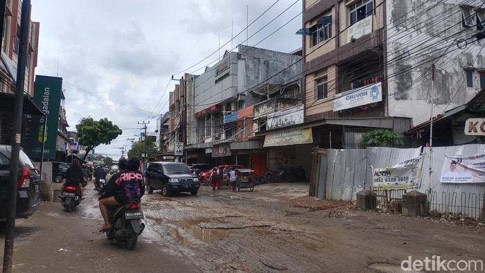 Jalan rusak dan tergenang di kawasan Segaran Palembang.