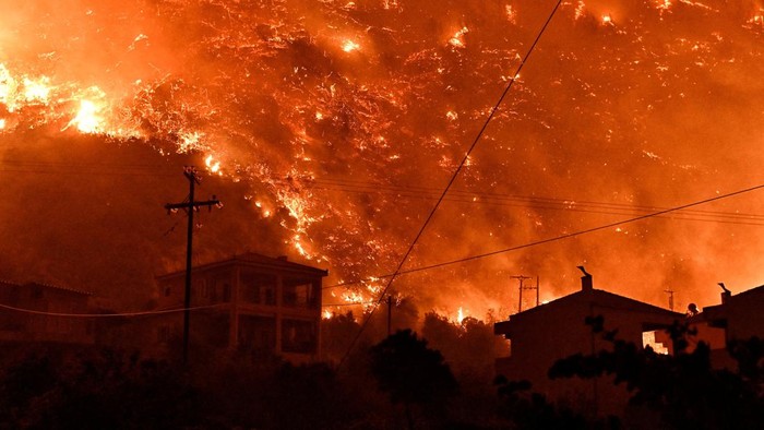Langit Yunani Berubah Oranye Akibat Kebakaran Hutan Hutan di pegunungan terjal wilayah Yunani tengah, Korintus ini mengalami kebakaran. Langit berubah menjadi oranye akibat kobaran api.