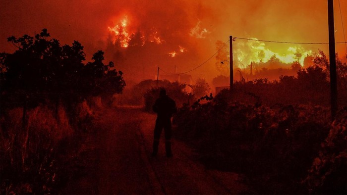 Langit Yunani Berubah Oranye Akibat Kebakaran Hutan Hutan di pegunungan terjal wilayah Yunani tengah, Korintus ini mengalami kebakaran. Langit berubah menjadi oranye akibat kobaran api.