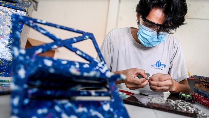 Penampakan Sampah Disulap Jadi Gantungan Kunci hingga Tatakan Gelas Pekerja menyelesaikan pembuatan gantungan kunci berbahan daur ulang sampah di rumah produksi Bank sampah Budiluhur, Tangerang, Banten, Senin (30/9/2024). Berbagai macam hasill kerajinan daur ulang sampah plastik seperti gantungan kunci dan alas gelas tersebut dijual dengan kisaran harga Rp25.000 sampai Rp5 juta. ANTARA FOTO/Rivan Awal Lingga/Spt.