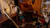 Rex Liberman memindahkan kulkasnya ke luar saat ia membersihkan rumahnya usai banjir akibat Badai Helene di Steinhatchee, Florida, AS, Minggu (29/9/2024).