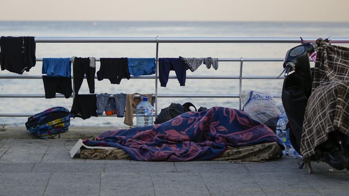 Families rest on Beirut's corniche after fleeing the Israeli airstrikes in Beirut's southern suburb, Lebanon, Monday, Sept. 30, 2024. (AP Photo/Hassan Ammar)