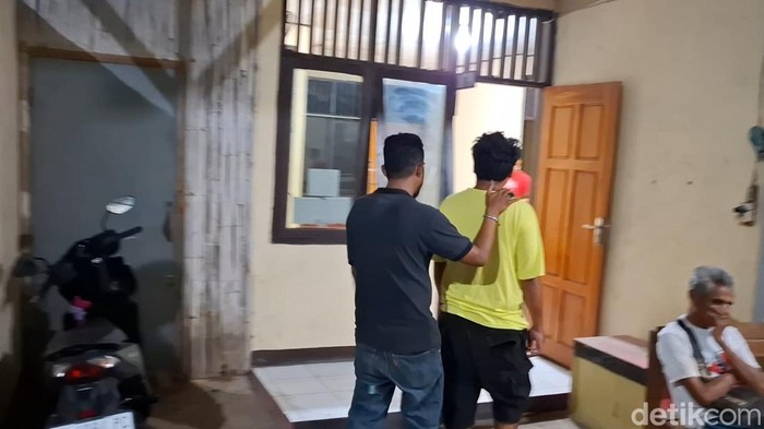 Polisi saat menggiring seorang saksi di Mapolsek Maulafa, Kota Kupang, NTT, Jumat (29/9/2024), pukul 23.41 Wita. (Yufengki Bria/detikBali).