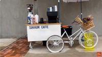 Sukhum Cafe juga menarik perhatian di Thailand. Pemiliknya menggunakan gerobak mungil yang disambungkan dengan sepeda untuk berjualan kopi yang nikmat. Untuk menambah estetika, sang pemilik menaruhkan beberapa buket bunga cantik. Foto: YouTube Tasty Inside