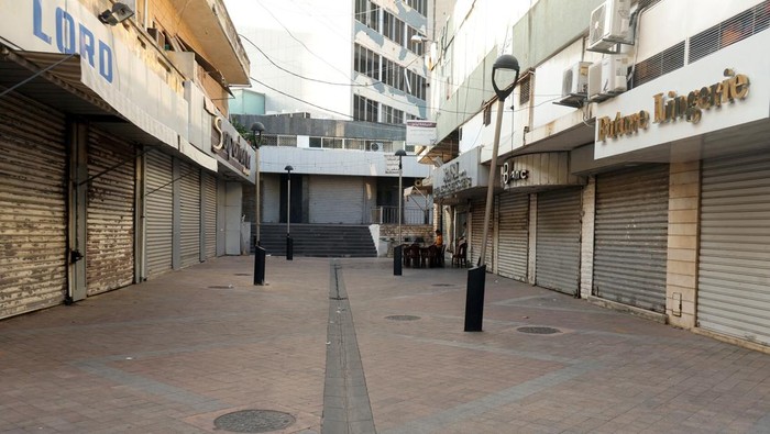 A coffee seller walks past closed shops, on the first of three days of mourning, after Hezbollah leader Sayyed Hassan Nasrallah was killed in Israeli air strike on Friday, in Sidon, Lebanon September 30, 2024. REUTERS/Aziz Taher