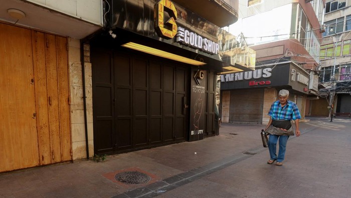 A coffee seller walks past closed shops, on the first of three days of mourning, after Hezbollah leader Sayyed Hassan Nasrallah was killed in Israeli air strike on Friday, in Sidon, Lebanon September 30, 2024. REUTERS/Aziz Taher