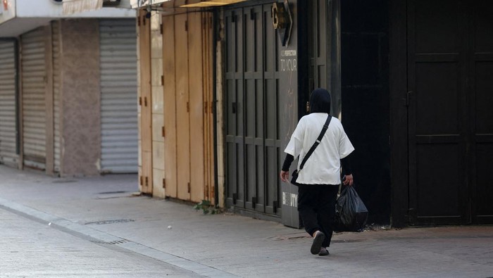 Toko-toko di Lebanon Tutup Saat Hari Berkabung Tewasnya Pimpinan Hizbullah A coffee seller walks past closed shops, on the first of three days of mourning, after Hezbollah leader Sayyed Hassan Nasrallah was killed in Israeli air strike on Friday, in Sidon, Lebanon September 30, 2024. REUTERS/Aziz Taher