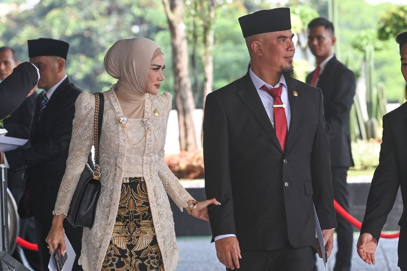 Pasangan artis sekaligus anggota DPR terpilih masa bakti 2024-2029 dari Partai Gerindra Ahmad Dhani Prasetya (kanan) dan Mulan Jameela (kiri) tiba di Gedung Nusantara untuk mengikuti pelantikan di Kompleks Parlemen, Senayan, Jakarta, Selasa (1/10/2024). Sebanyak 580 anggota DPR dan 152 anggota DPD dilantik dan diambil sumpah jabatanya untuk masa bakti 2024-2029. ANTARA FOTO/Dhemas Reviyanto/app/rwa.