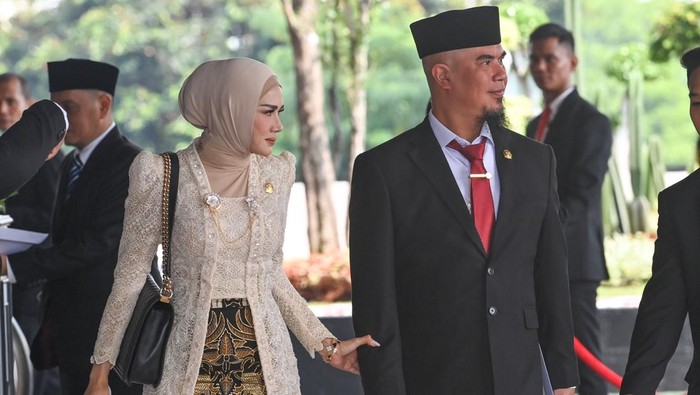 Pasangan artis sekaligus anggota DPR terpilih masa bakti 2024-2029 dari Partai Gerindra Ahmad Dhani Prasetya (kanan) dan Mulan Jameela (kiri) tiba di Gedung Nusantara untuk mengikuti pelantikan di Kompleks Parlemen, Senayan, Jakarta, Selasa (1/10/2024). Sebanyak 580 anggota DPR dan 152 anggota DPD dilantik dan diambil sumpah jabatanya untuk masa bakti 2024-2029. ANTARA FOTO/Dhemas Reviyanto/app/rwa.