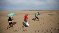 Pemandangan dari drone menunjukkan orang-orang membawa makanan dan air ke desa mereka yang terisolasi di atas gundukan pasir yang terpapar kekeringan di Sungai Solimoes, selama kekeringan paling parah dan meluas yang dialami Brasil sejak pencatatan dimulai pada tahun 1950, dekat Manacapuru, negara bagian Amazonas, Brasil.